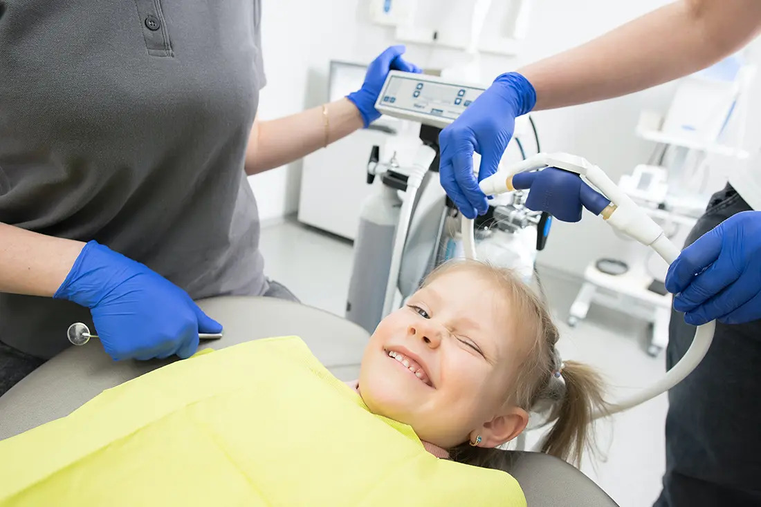 A photo of a relaxed child resting comfortably during a pediatric dental procedure with sedation care.