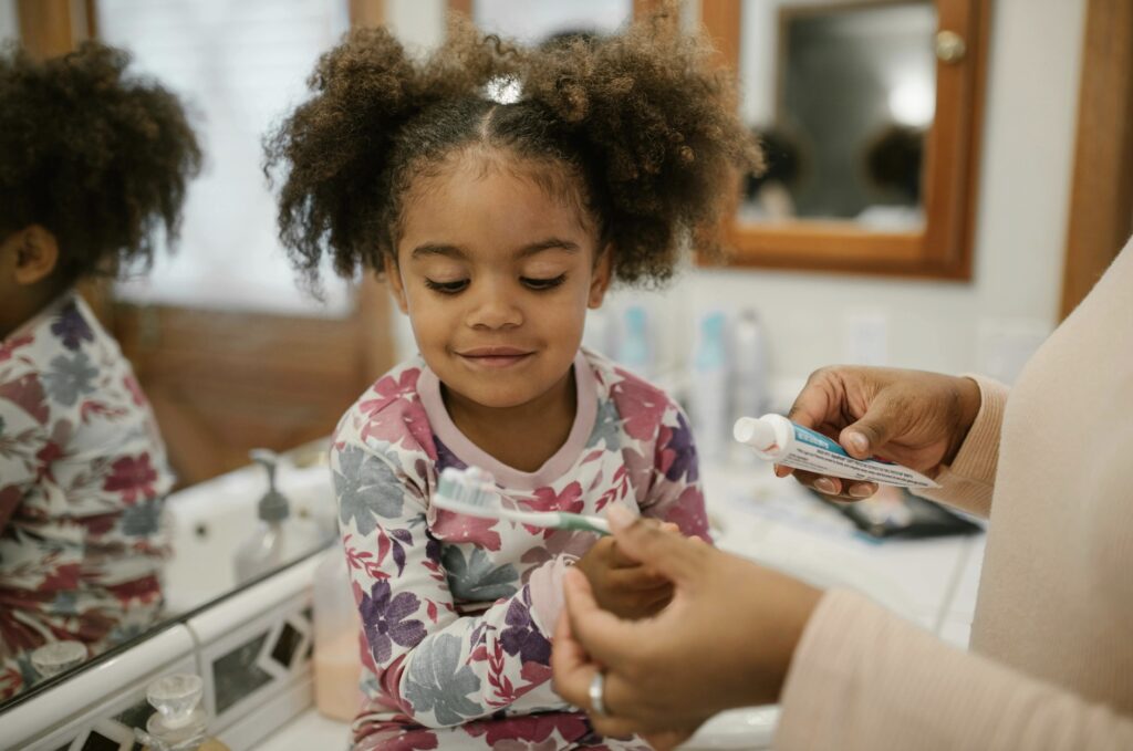 A photo of a parent helping a young child brush their teeth at home, creating a calm and positive dental care routine.