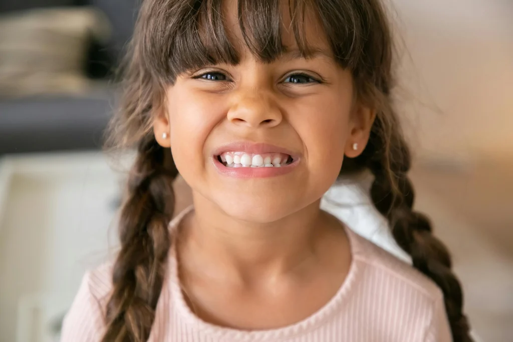 photo-of-a-girl-with-two-braids-smiling-with-her-teeth