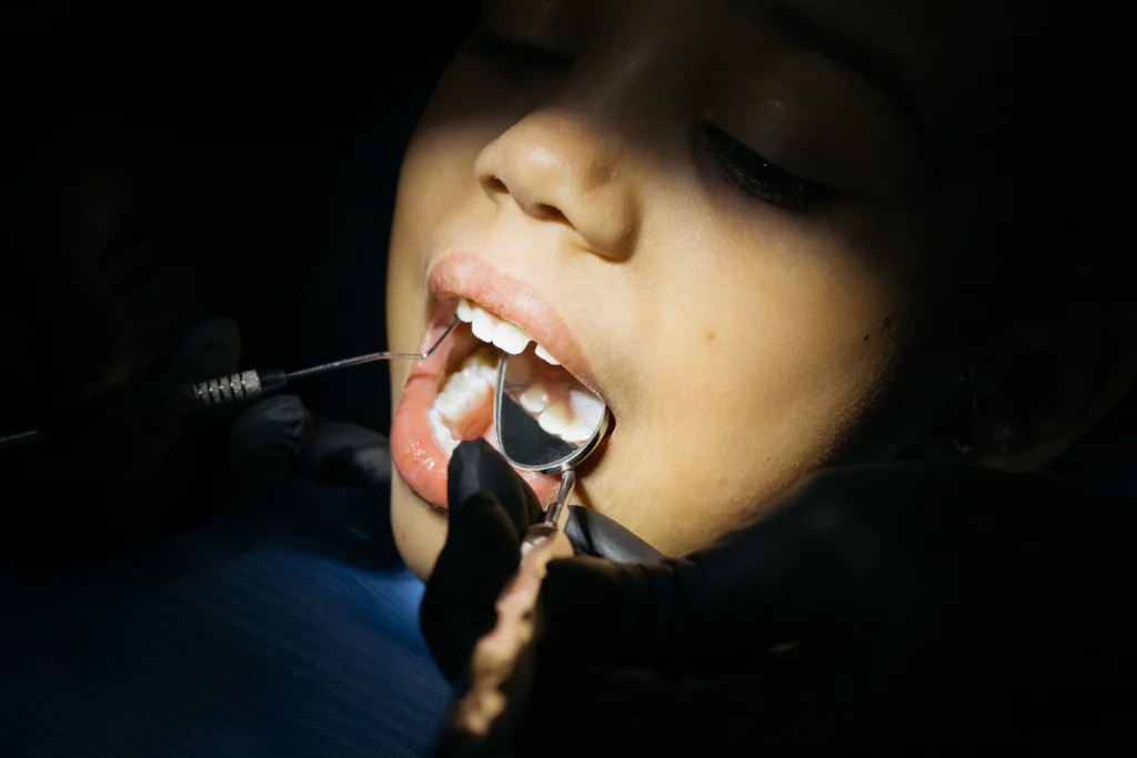 photo-of-a-child-getting-his-teeth-checked-by-a-dentist
